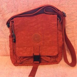 Used Kipling orange crossover bag.